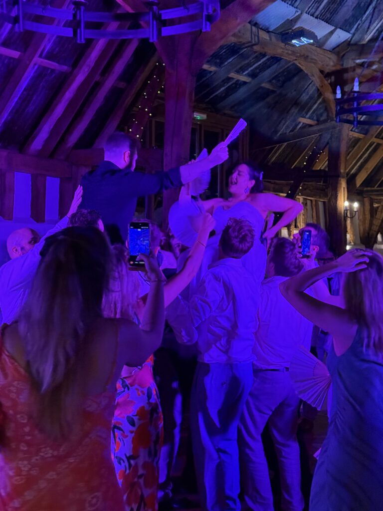 Bride celebrating on a packed wedding dancefloor with Mr Beats Wedding DJ